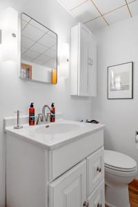 a white bathroom with a sink and a toilet at Lake Pulaski Getaway in Buffalo
