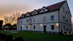 a large white house with a sunset in the background at The View 22 in Cerklje na Gorenjskem