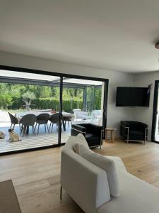 ein Wohnzimmer mit einer weißen Couch und einem Tisch in der Unterkunft Maison proche centre de Montpellier au calme in Saint-Clément-de-Rivière