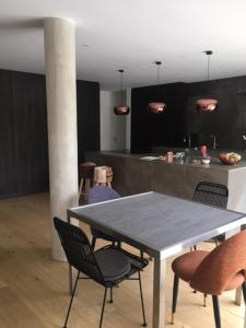 ein Tisch und Stühle in einem Raum mit Küche in der Unterkunft Maison proche centre de Montpellier au calme in Saint-Clément-de-Rivière