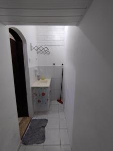 La salle de bains est pourvue d'un lavabo et de carrelage blanc. dans l'établissement Seu Apto na Praia da Costa 6 Excelente Local Ar Cond TV Microondas Internet Rápida Todo seu Centro, à Vila Velha