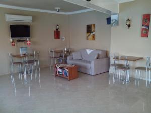 a living room with a couch and a table and chairs at Hotel Bella Vista in Samos