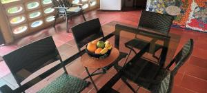 una mesa y sillas con un bol de fruta. en Villa Margarita en Puerto Colombia