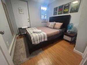 a bedroom with a bed with a plaid blanket at Park view South of Boston - Quincy in Quincy