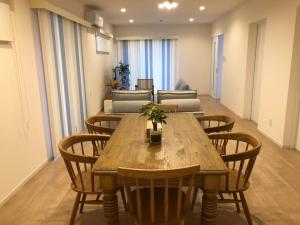 a dining room with a wooden table and chairs at Bears Stay Kumejima Villa - Vacation STAY 01040v in Kumejima