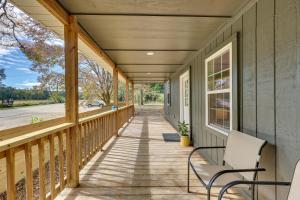 a porch of a home with two chairs at Rice Creek Hideaway with Private Dock and Boardwalk 