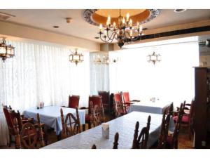 un comedor con 2 mesas y sillas y una lámpara de araña en Green Hotel Rich Tokugawaen - Vacation STAY 02759v, en Okazaki