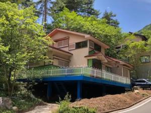 uma casa com uma varanda com árvores em frente em Hinata Sanso - Vacation STAY 02668v em Azumino
