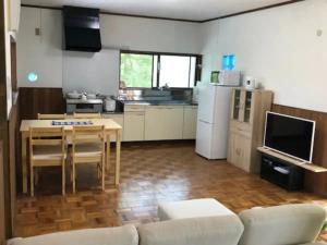 a living room with a table and a kitchen at Hinata Sanso - Vacation STAY 02668v in Azumino