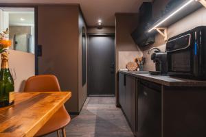 a kitchen with a wooden table and a microwave at Aera - Glass cabins in Tromsø