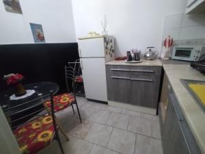 uma cozinha com um frigorífico branco, uma mesa e cadeiras em AL Civico 24 em Acerra