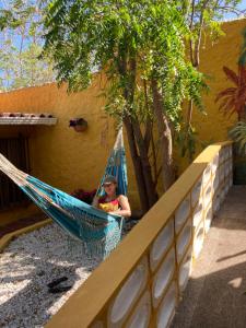 Ein Mann, der in einer Hängematte im Garten sitzt. in der Unterkunft Villa Margarita in Puerto Colombia