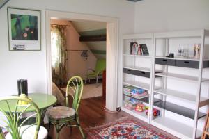 a living room with a table and a book shelf at Chambres D'hotes Du Vignoble in Riquewihr