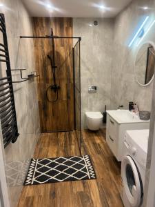 La salle de bains est pourvue d'une douche, de toilettes et d'un lavabo. dans l'établissement Apartament Manhattan, à Tarnobrzeg