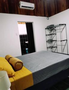 a bedroom with a bed with yellow sheets and a window at Pura Vida House in Quepos