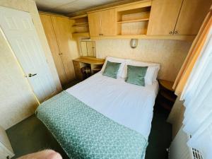 a small bedroom with a bed in a small room at 2 Bedroom Caravan SHS3, Sandhills, Bembridge in Bembridge