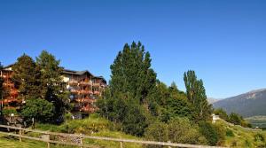 a resort on a hill with trees and a fence at Les Balcons Du Soleil in Font-Romeu