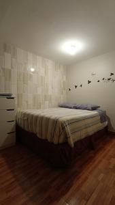 um quarto com uma cama com pássaros na parede em el valle em Copiapó