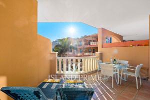 un balcone con tavolo e sedie e un edificio di El Nautico Relax in Golf del Sur a San Miguel de Abona