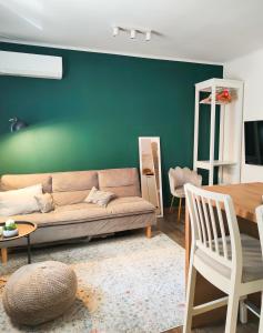 Una sala de estar con un sofá y una pared verde. en Mercado Central 1 - 55'' TV, en Alicante
