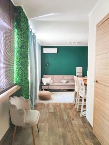 Una sala de estar con un sofá y una pared verde. en Mercado Central 1 - 55'' TV, en Alicante