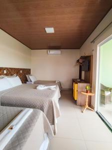 um quarto de hotel com duas camas e uma janela em POUSADA CAJUEIRO em Santo Amaro