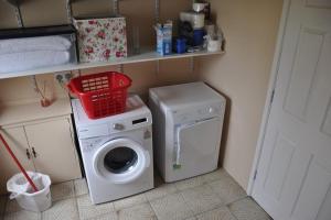 a laundry room with a washing machine and a washer at Swallows Haven in Moneyreagh