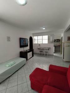 ein Wohnzimmer mit einem roten Sofa und einem TV in der Unterkunft Seu Apto na Praia da Costa 7 Completo 2Q 2B 2S Ar Cond Geladeira Fogao TV Maq Lavar Centro Sem escadas in Vila Velha
