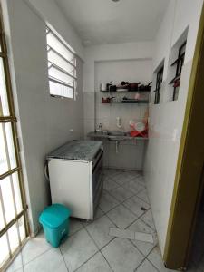 Elle comprend une petite salle de bains blanche pourvue d'un lavabo et de toilettes. dans l'établissement Seu Apto na Praia da Costa 7 Completo 2Q 2B 2S Ar Cond Geladeira Fogao TV Maq Lavar Centro Sem escadas, à Vila Velha