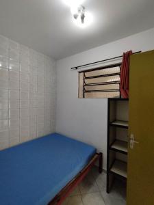 Cette petite chambre comprend un lit bleu et des lits superposés. dans l'établissement Seu Apto na Praia da Costa 7 Completo 2Q 2B 2S Ar Cond Geladeira Fogao TV Maq Lavar Centro Sem escadas, à Vila Velha
