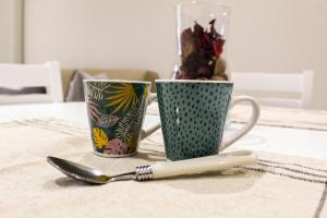 dos tazas de café y una cuchara en una mesa en Corte dell'Ulivo, en San Giuliano Terme
