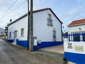 uma rua com dois edifícios brancos e azuis em Casa Tia Maria em Moledo