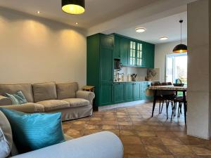 uma sala de estar com armários verdes e um sofá em Casa Tia Maria em Moledo