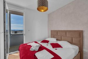 a bedroom with a large bed with red and white pillows at Apartment Ivana in Makarska