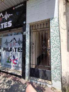 a front door of a store with a gate at Seu Apto na Praia da Costa 7 Completo Simples e Barato 2Q Ar Cond Geladeira Fogao TV no Centro Bom para Empresas Sem escadas in Vila Velha