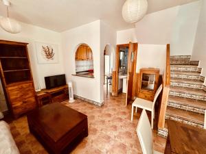 een woonkamer met een bank, een tv en een trap bij Gran Alacant Bea's house in Gran Alacant