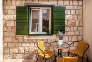 a table and chairs sitting in front of a window at Apartments Mande and Kate in Baška Voda