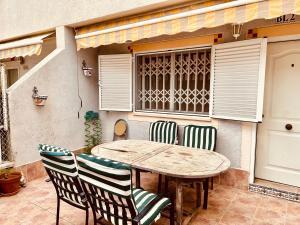 een houten tafel en stoelen op een patio bij Gran Alacant Bea's house in Gran Alacant