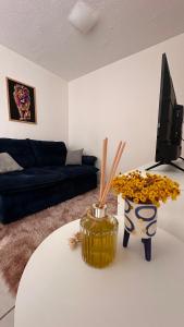 a living room with a white table and a tv at Ap Confort Premium in Campinas