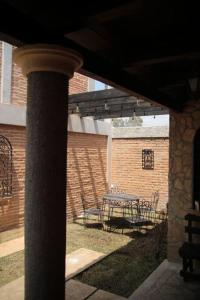 patio con mesa, sillas y pared de ladrillo en Casa Fátima, en San Cristóbal de Las Casas