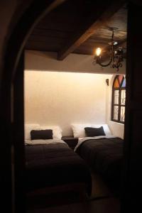 2 camas en una habitación con ventana en Casa Fátima, en San Cristóbal de Las Casas