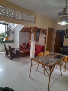 Pied a terre in Ouakam في Ouakam: غرفة معيشة مع طاولة زجاجية وأريكة