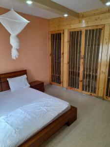 1 dormitorio con 1 cama y algunas ventanas en Pied a terre in Ouakam, en Ouakam