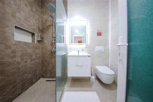 y baño con aseo, lavabo y ducha. en Hotel Apartments Ardi & Lala, en Peje