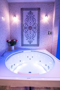 Diamond Suites by Reykjavik Keflavik Airport في كيفلافيك: حوض استحمام في حمام مع صورة على الحائط