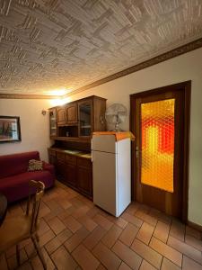 eine Küche mit einem Kühlschrank und einer roten Couch in der Unterkunft villa Angelina house in Ripa Teatina