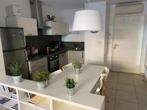 a kitchen with a white table with plants on it at Appartement climatisé 50m2 centre du village in Porquerolles
