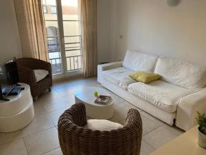 a living room with a couch and a table at Appartement climatisé 50m2 centre du village in Porquerolles