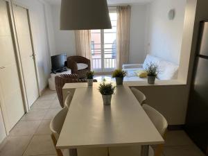 a white table in a living room with plants on it at Appart neuf 50m² Porquerolles centre du village in Porquerolles