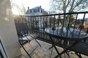 a balcony with a table and chairs on a fence at Dammarie-les-Lys : Superbe studio avec jacuzzi in Dammarie-lès-Lys